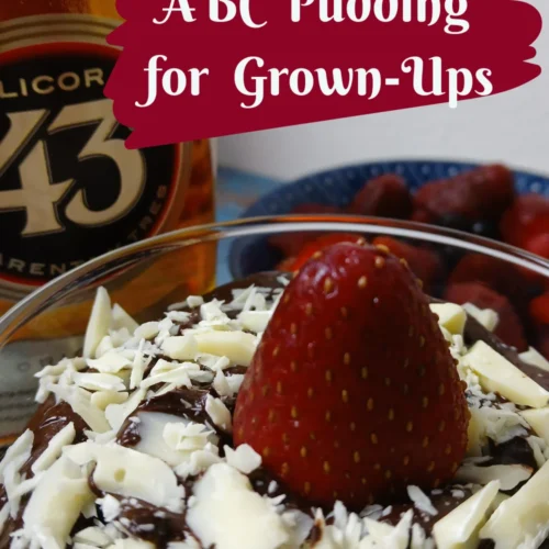 A bowl of chocolate pudding topped with a strawberry and white chocolate shavings sits next to a bottle of Licor 43 liqueur and a bowl of raspberries. Text reads ABC Pudding for Grown-Ups.