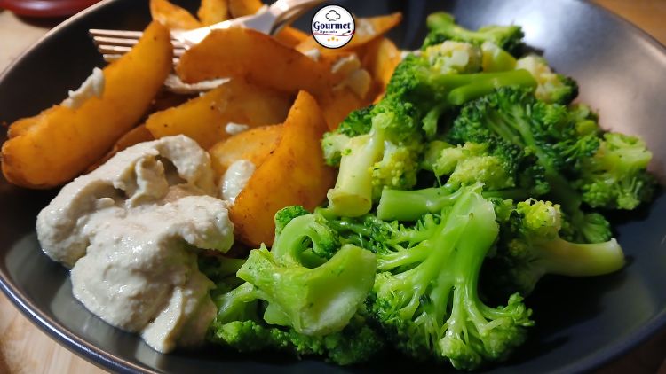 A black plate filled with steamed broccoli, golden potato wedges, and a creamy dip offers the perfect option for 5-minute meals. A fork rests on the side, while the Gourmet Spoonie logo is visible in the background.