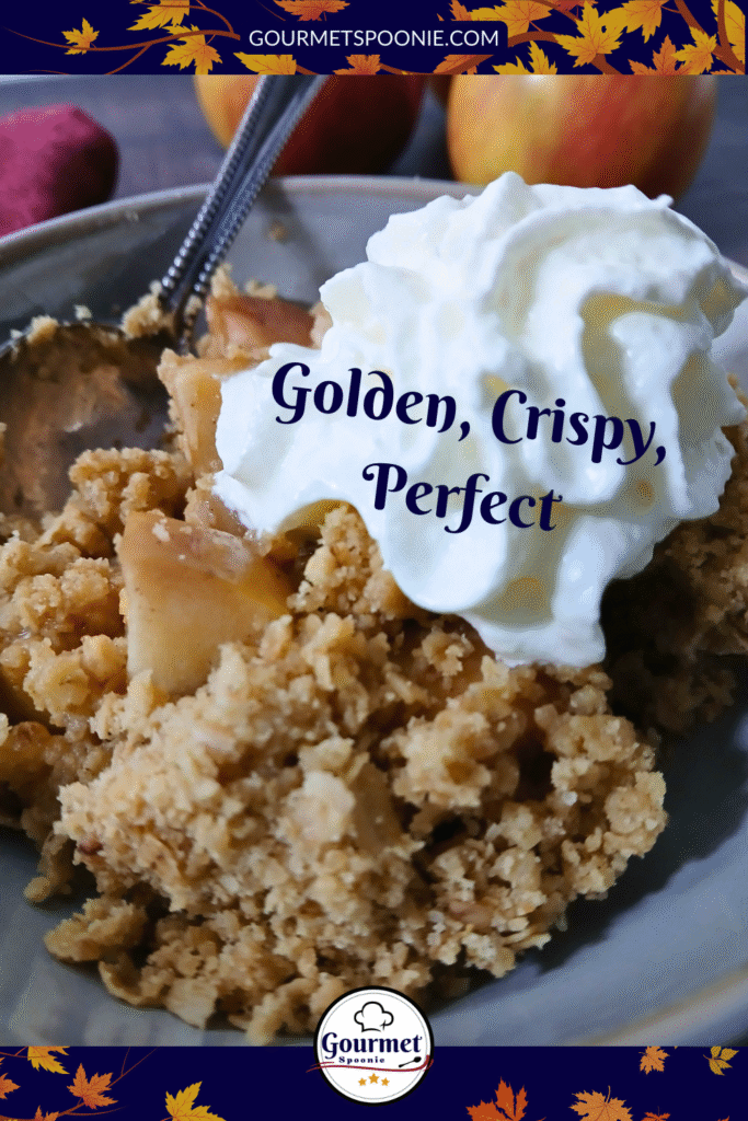 A close-up of a serving of easy apple crumble topped with whipped cream on a plate with a spoon. The text reads Golden, Crispy, Perfect. Autumn leaves border the image and a Gourmet logo appears at the bottom.