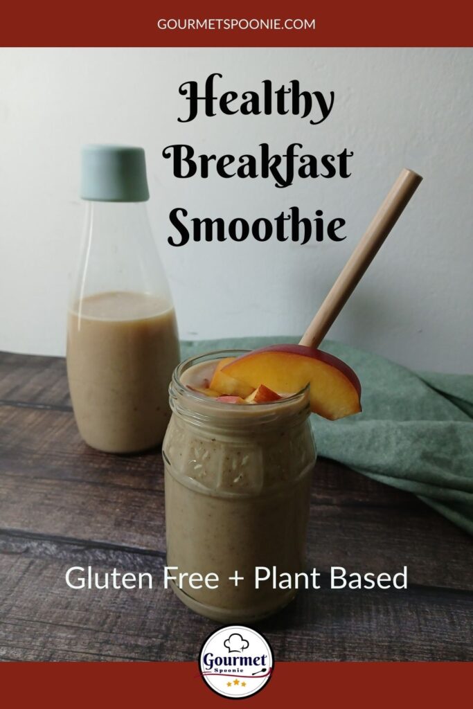 A mason jar filled with a smoothie, topped with peach slices and a straw, sits on a wooden table in front of a glass bottle of smoothie. Text on the image reads: Healthy Breakfast Smoothie. Gluten Free + Plant Based.