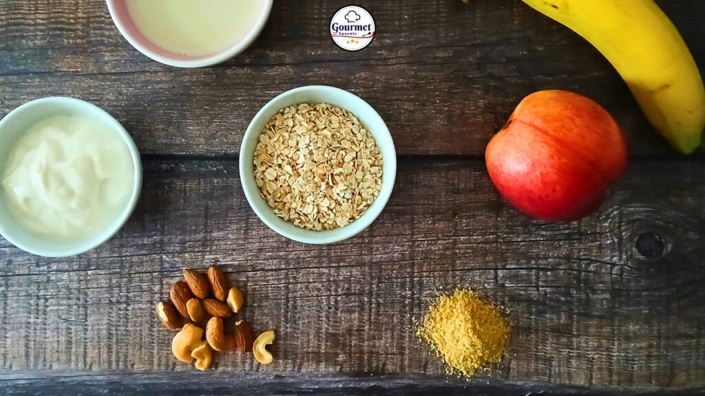 A flat lay of ingredients for a plant based breakfast thats easy to digest on a wooden table: a bowl of yogurt, oats, a peach, banana, brown sugar, assorted nuts, and a small dish of milk.