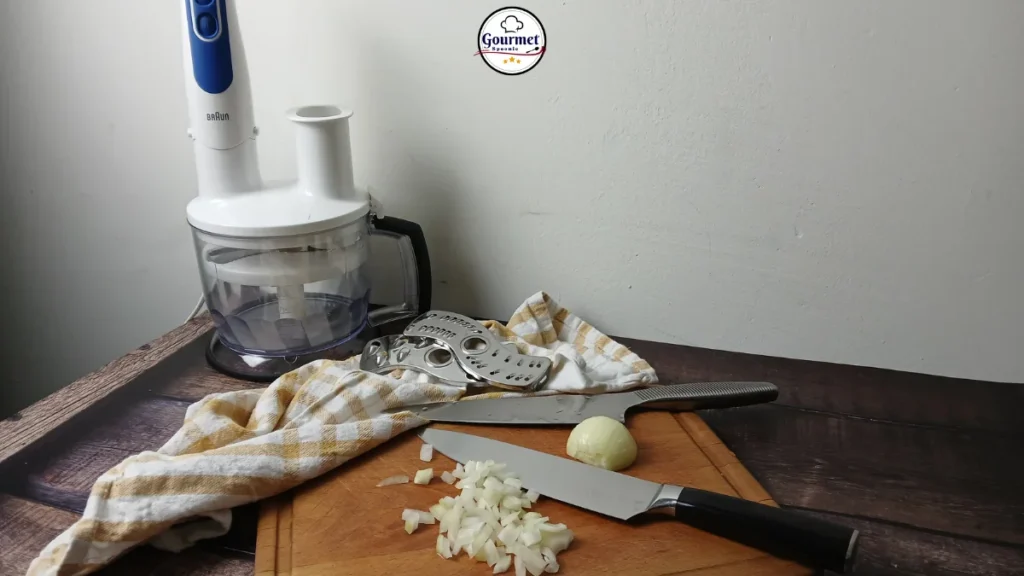Chef’s knives and a food processor on a kitchen counter, demonstrating practical alternatives to L-shaped knife adaptive design tools for disabled cooks.