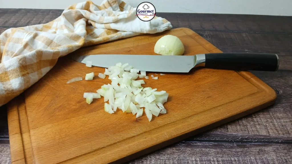 Japanese chef’s knife on a wooden board with chopped onion, showing traditional knife use as a safe option compared with L-shaped or angled knives for accessible cooking.