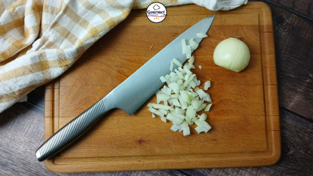 Ikea 365+ chef’s knife on a wooden chopping board with a partly chopped onion, showing a practical alternative to L-shaped knives and other angled knife designs for accessible cooking.