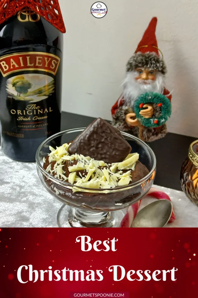 A glass bowl of chocolate dessert topped with white chocolate shavings and an After Eight, next to a Baileys bottle and a festive Santa figurine. Text reads: 'Best Christmas Dessert.'.