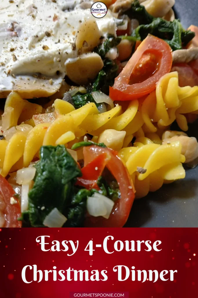Close-up of a plate with yellow spiral pasta, fresh spinach, sliced cherry tomatoes, onions, mushrooms, and a creamy sauce. Text at the bottom reads: 'Easy 4-Course Christmas Dinner.'.