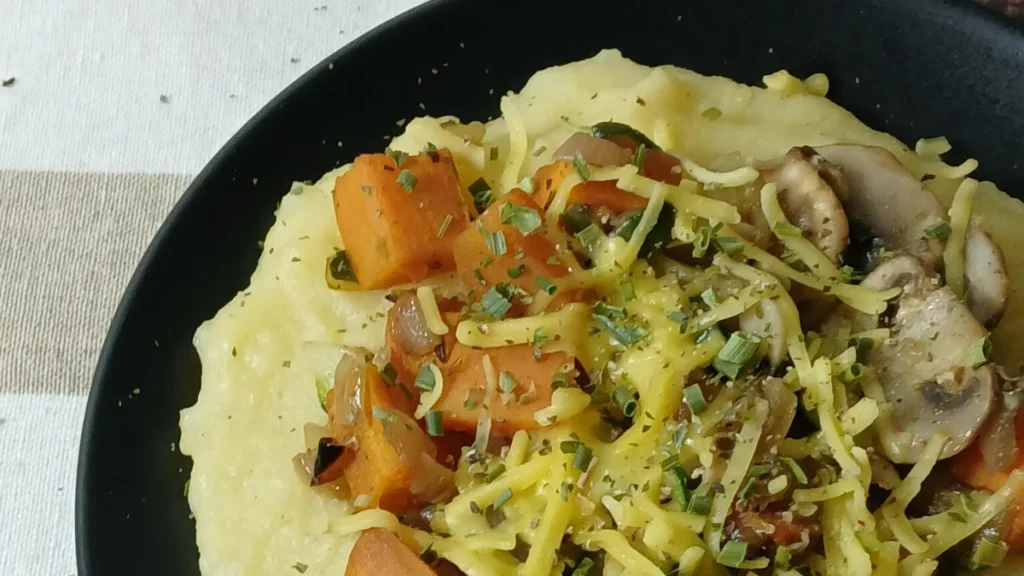 close up of easy slow cooker polenta with veggies and vegan Parmesan