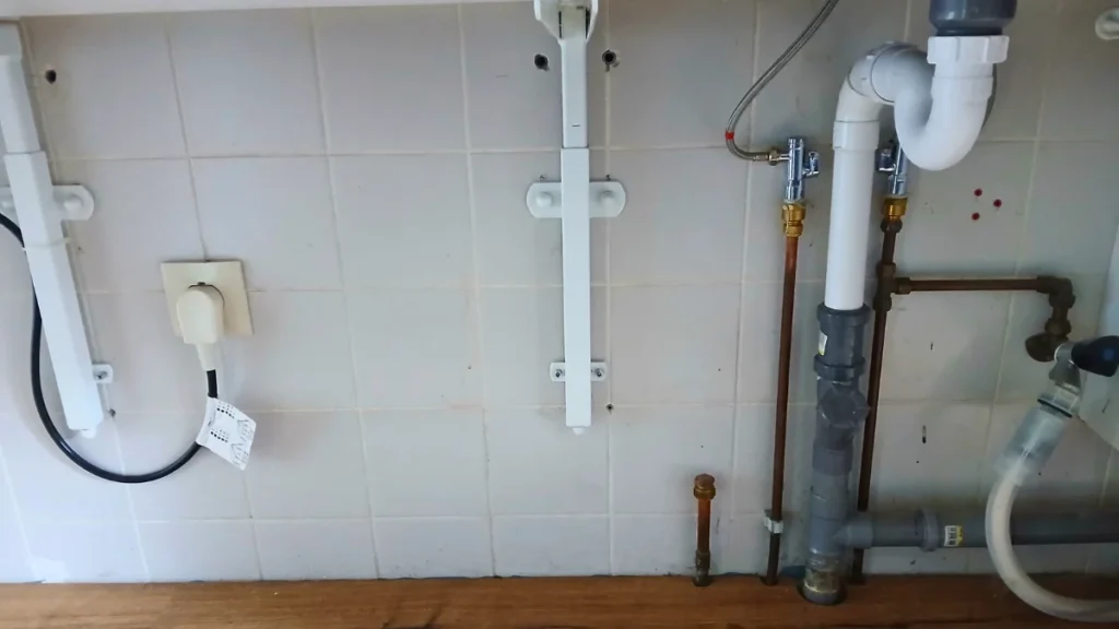  visible pipes, drains, and cable in a wheelchair-friendly kitchen.