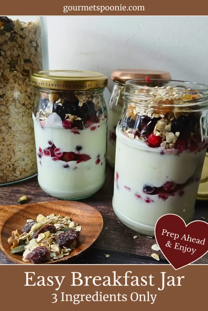 Muesli and yoghurt parfait in glass jars with layers of yoghurt, berries, and gluten-free muesli, styled as a healthy make-ahead breakfast.
