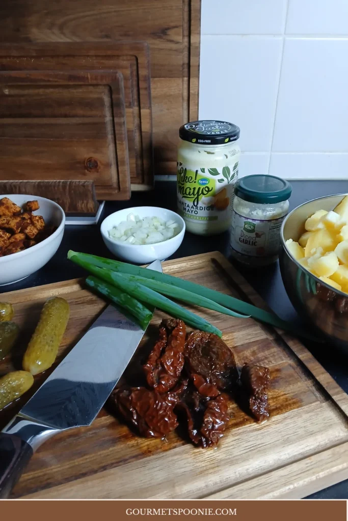 Ingredients for easy vegan potato salad laid out on a chopping board.