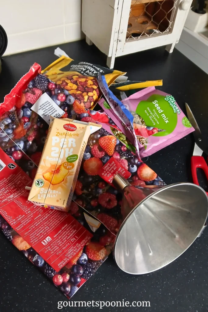 Behind the scenes: empty packaging, a funnel, and a pair of scissors on a kitchen worktop after a photoshoot
