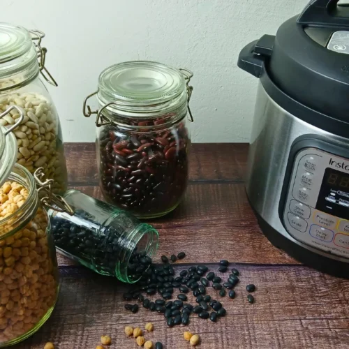 instant pot and jars of dried beans on wooden table