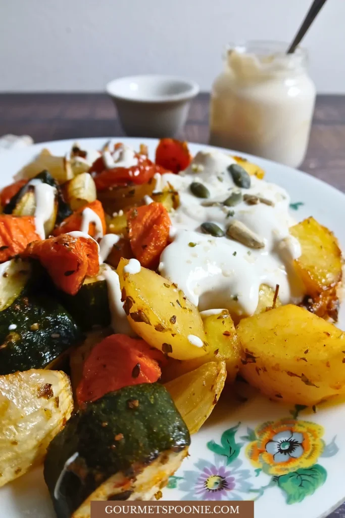 Serving of roasted vegetable traybake with creamy sauce on a plate