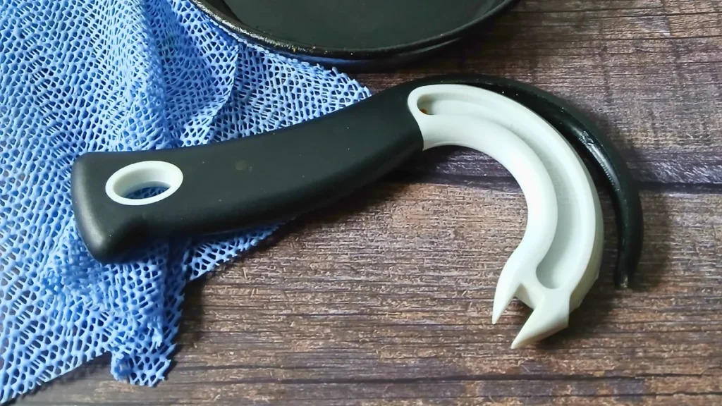 Worn adaptive kitchen tools on wooden table.