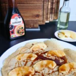 Gluten-free vegan Dutch pancake with apple slices and cinnamon, lightly browned