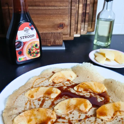 Gluten-free vegan Dutch pancake with apple slices and cinnamon, lightly browned
