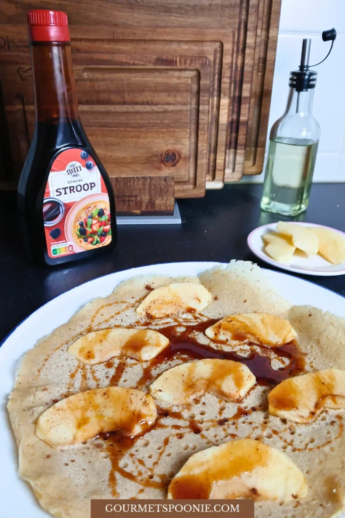 Gluten-free vegan Dutch pancake with apple slices and cinnamon, lightly browned