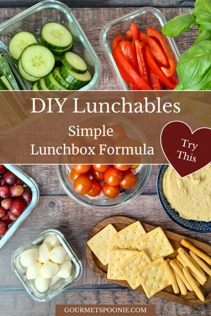 Ingredients for DIY lunchables including vegetables, gluten-free crackers, hummus, and fruit arranged on a table.