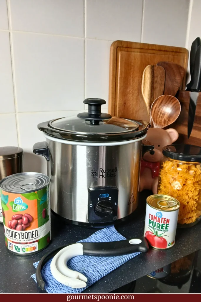 Mini slow cooker and well-used adaptive kitchen tools on a kitchen counter in a Spoonie kitchen.