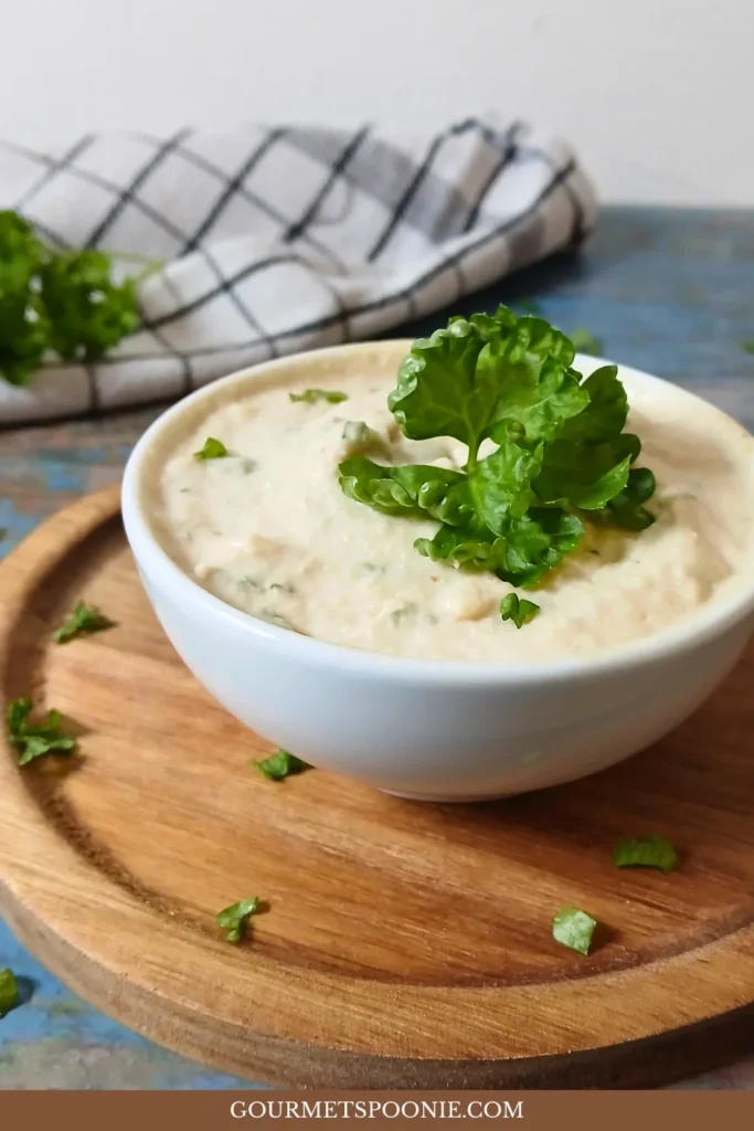 Paturain-style vegan cream cheese topped with chopped parsley in a small bowl