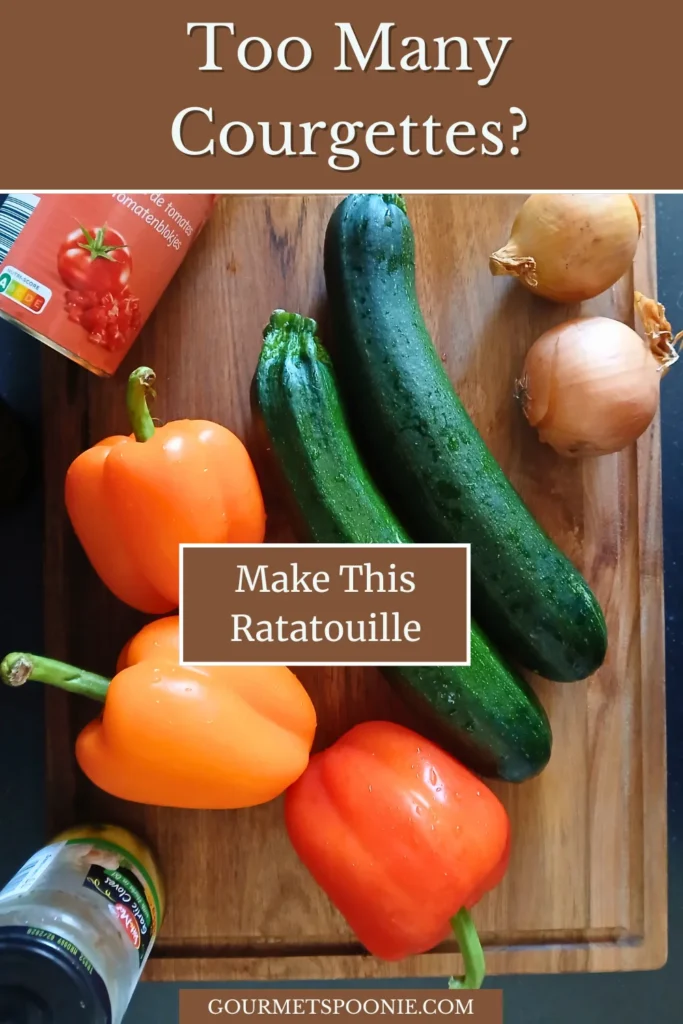 Flat lay of courgettes, peppers, onions, potatoes, tomatoes, garlic, and herbs for slow cooker ratatouille.