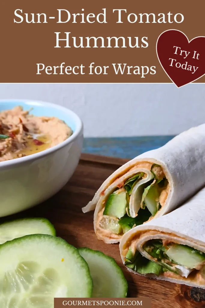 Gluten-free wrap filled with hummus and cucumber beside a bowl of homemade sun-dried tomato hummus.