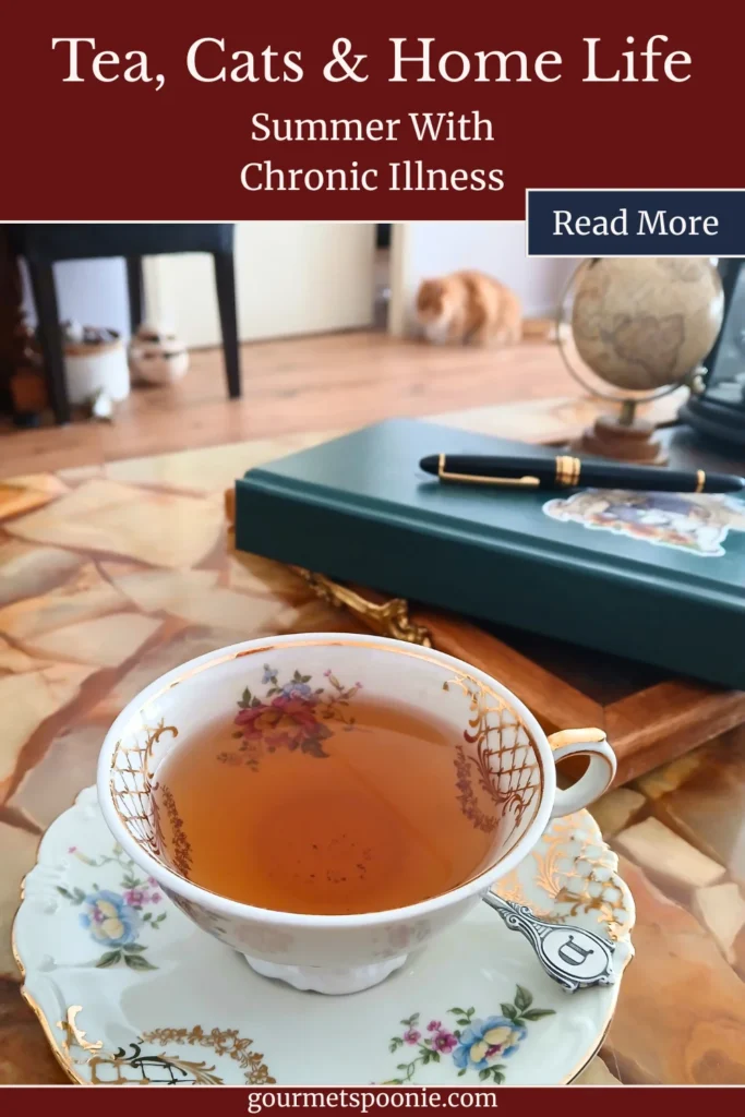 Decorative teacup of tea on a table with a cat relaxing in the background of a cosy home.