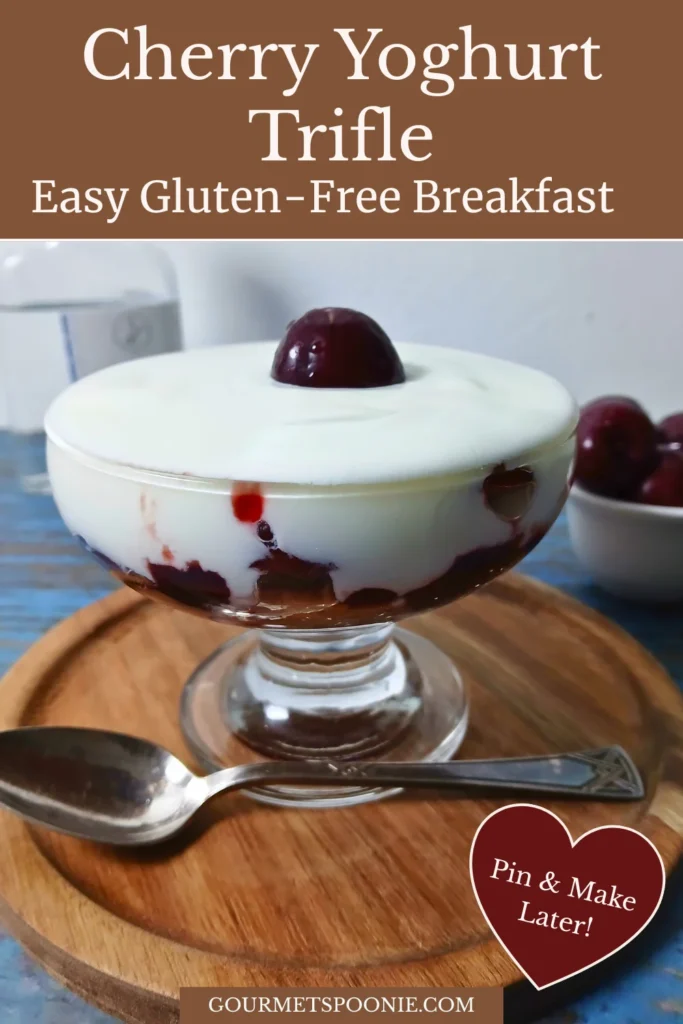 Single-serving cherry yoghurt trifle layered with cake, cherry jam, fresh cherries, and creamy yoghurt in a glass dessert bowl.