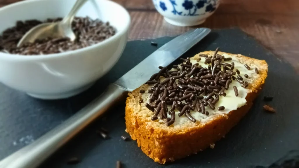 A slice of banana bread with chocolate sprinkles. One of 10+ gluten free vegan breakfast ideas for Spoonies.