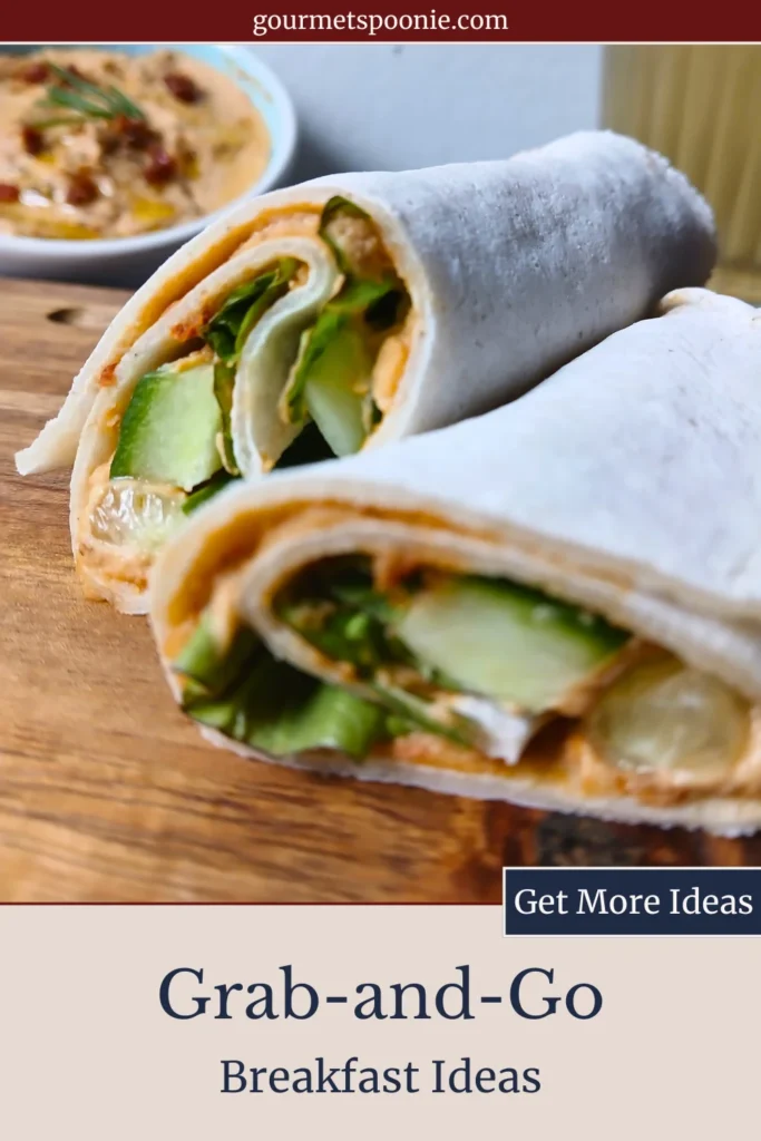 A gluten-free wrap filled with hummus, cucumber, and leafy greens, cut in half on a wooden board.